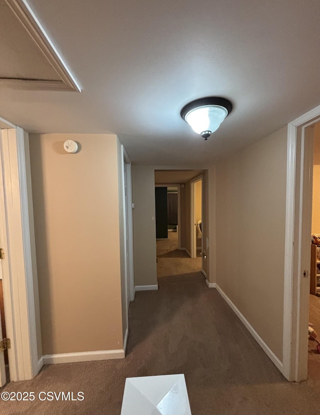 hall featuring dark colored carpet