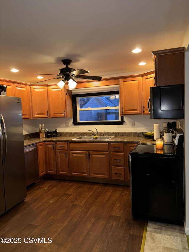 kitchen featuring dark wood-type flooring, sink, stainless steel appliances, and ceiling fan