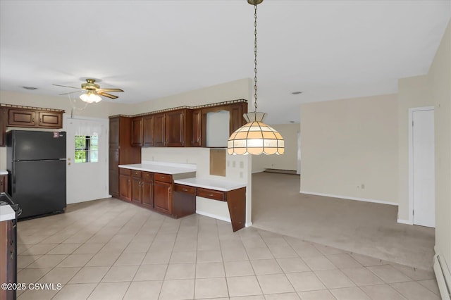 kitchen featuring baseboard heating, pendant lighting, black refrigerator, light carpet, and ceiling fan