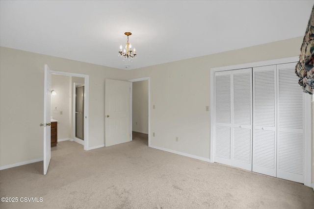 unfurnished bedroom featuring a closet, an inviting chandelier, and light carpet