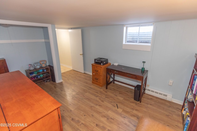 office area with light hardwood / wood-style flooring and a baseboard radiator