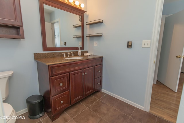 bathroom featuring toilet, tile patterned flooring, and vanity