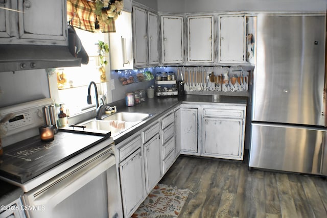 kitchen featuring dark wood-type flooring, white range with electric stovetop, sink, and stainless steel refrigerator