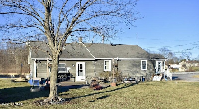 rear view of house featuring a lawn