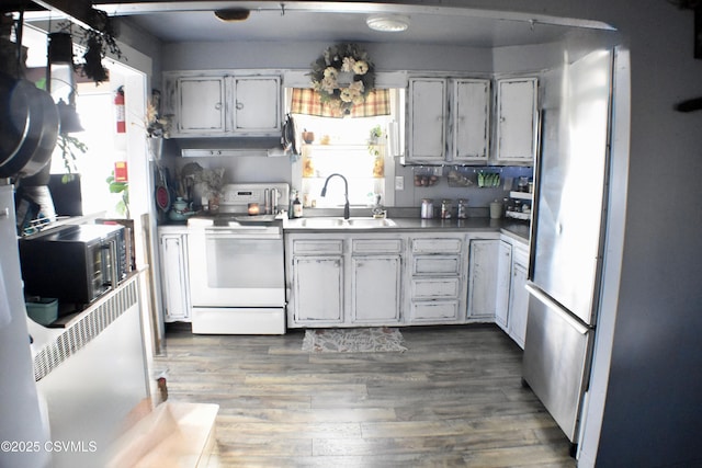 kitchen with sink, white range with electric stovetop, dark hardwood / wood-style floors, and plenty of natural light