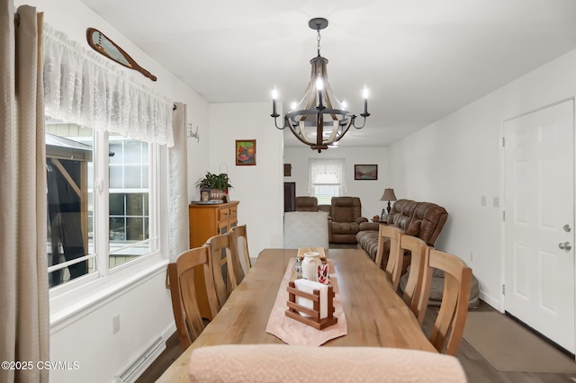 dining room with an inviting chandelier, baseboard heating, and hardwood / wood-style flooring