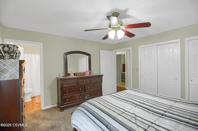 bedroom featuring ceiling fan, a closet, light colored carpet, and ensuite bath