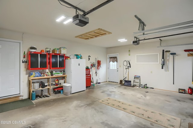 garage with a garage door opener and white fridge