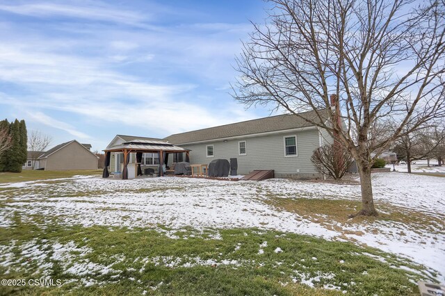 snow covered rear of property with a gazebo