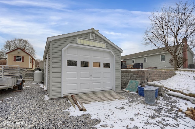 snow covered garage with cooling unit