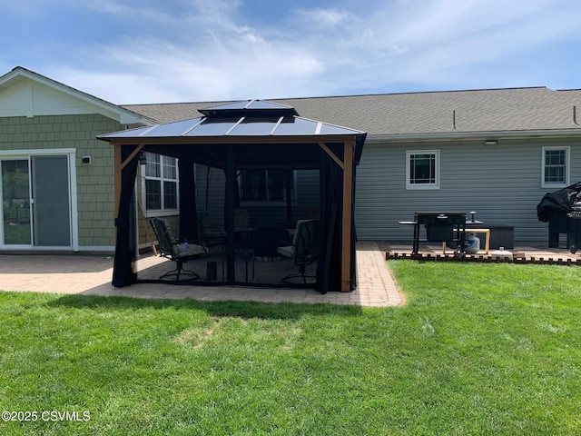 rear view of house with a gazebo, a lawn, and a patio