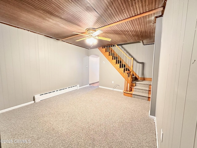 basement with baseboard heating, wood ceiling, wood walls, carpet flooring, and ceiling fan