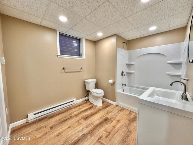 full bathroom featuring toilet, hardwood / wood-style floors, a baseboard heating unit, shower / tub combination, and vanity