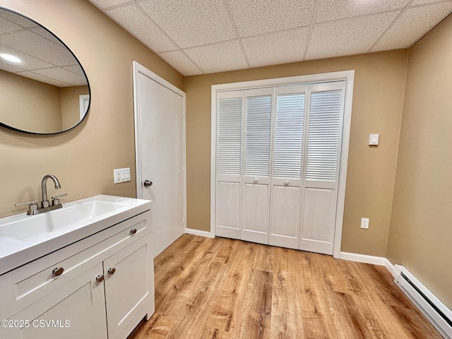 bathroom with baseboard heating, hardwood / wood-style floors, and vanity