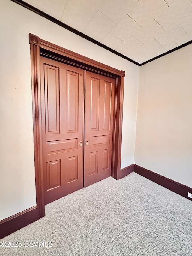 unfurnished bedroom with carpet and crown molding