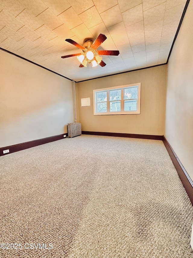 carpeted empty room featuring ceiling fan and radiator