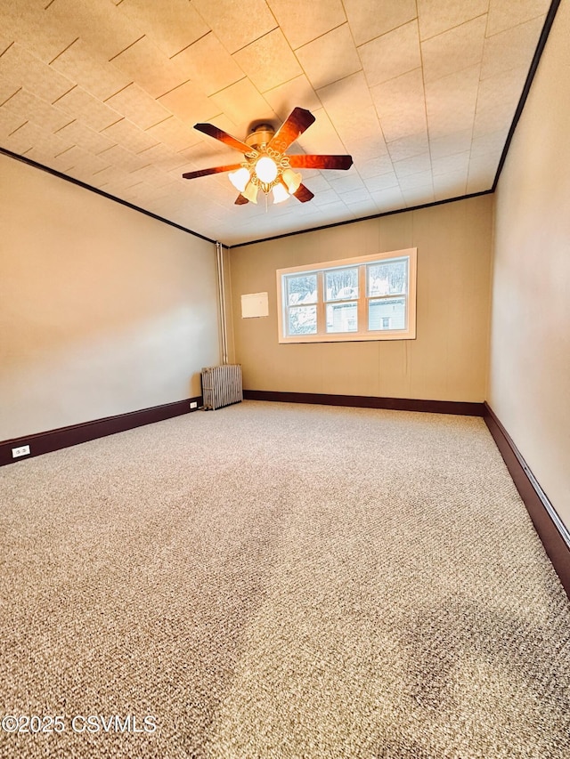 spare room with ceiling fan, carpet, and crown molding