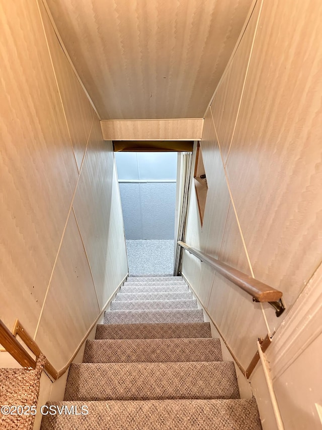 stairs featuring wood walls and wood ceiling