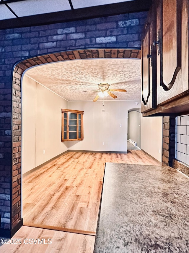 unfurnished living room featuring ceiling fan and hardwood / wood-style flooring