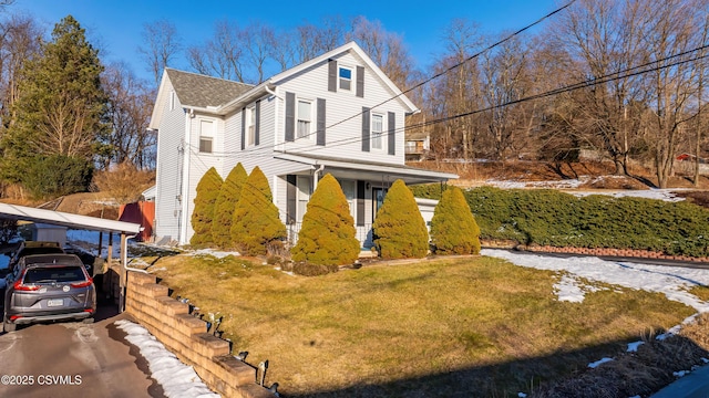 view of property exterior with a lawn, a carport, and covered porch