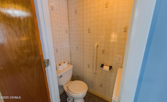 bathroom featuring tile walls and toilet