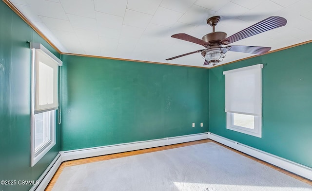 spare room with crown molding, hardwood / wood-style flooring, ceiling fan, and baseboard heating