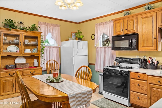 kitchen featuring gas range, crown molding, a chandelier, light tile patterned floors, and white refrigerator