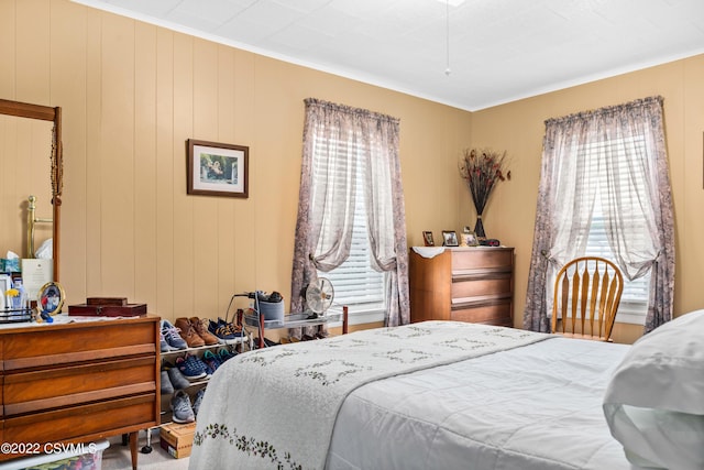 bedroom featuring ornamental molding and wooden walls