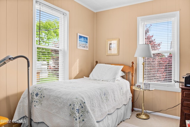 bedroom featuring crown molding, carpet, and wooden walls