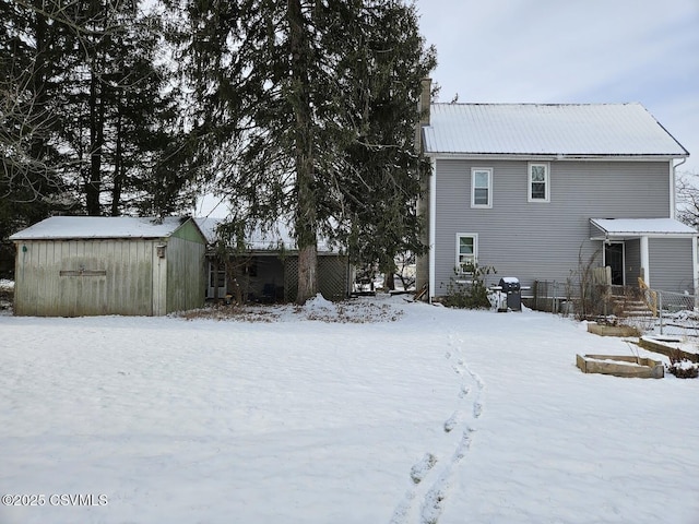 snow covered property with a storage shed