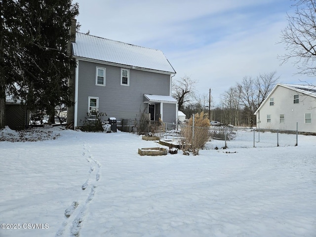 view of snow covered rear of property