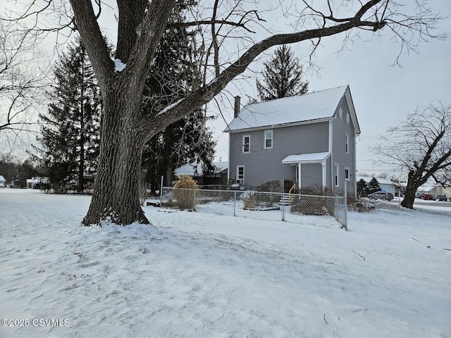 view of snow covered back of property