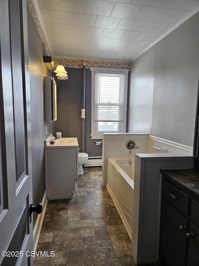 bathroom with toilet, baseboard heating, a tub, crown molding, and vanity