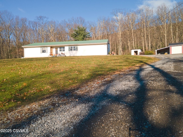 view of front of house with a front lawn, a garage, and an outdoor structure