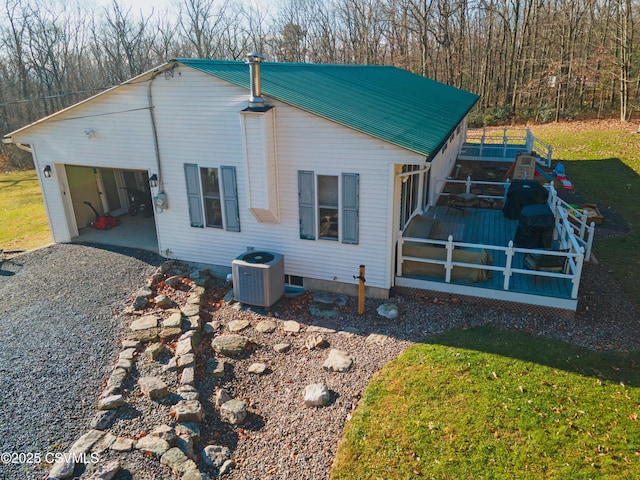 rear view of property featuring a lawn, cooling unit, a garage, and a sunroom