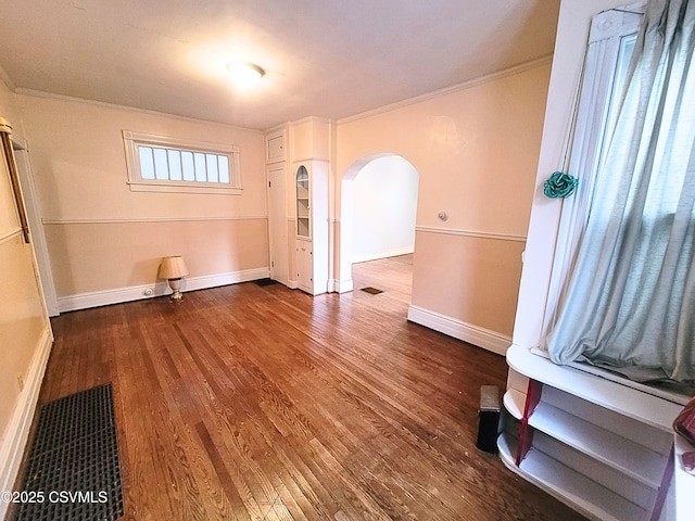 empty room featuring wood-type flooring and ornamental molding