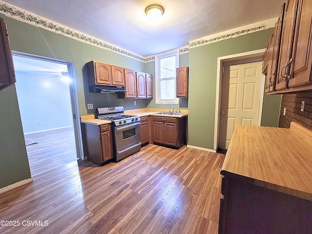 kitchen featuring gas range, light hardwood / wood-style floors, and sink