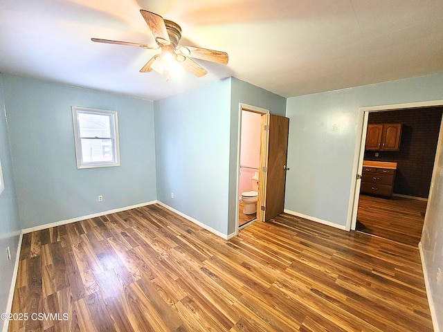 unfurnished bedroom with ceiling fan, dark wood-type flooring, and connected bathroom