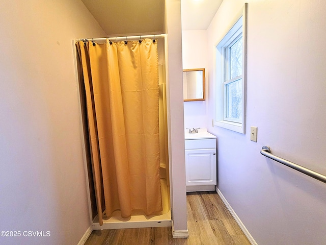 bathroom featuring hardwood / wood-style floors, walk in shower, and vanity