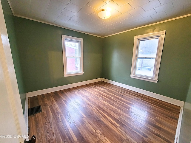 unfurnished room with a healthy amount of sunlight, crown molding, and dark hardwood / wood-style flooring