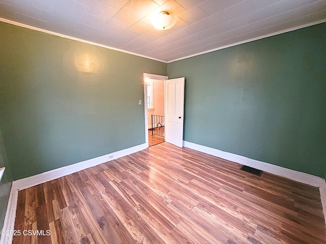 unfurnished room with wood-type flooring and ornamental molding