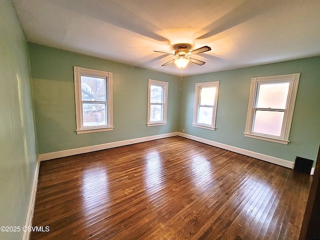 spare room with dark wood-type flooring and ceiling fan