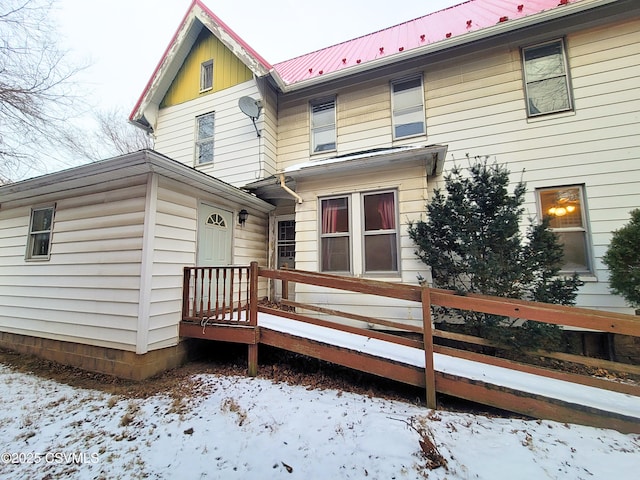 view of snow covered back of property