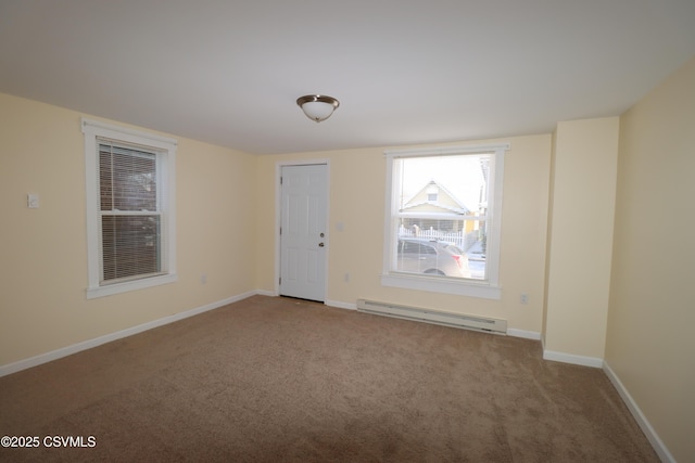 carpeted empty room with a baseboard heating unit