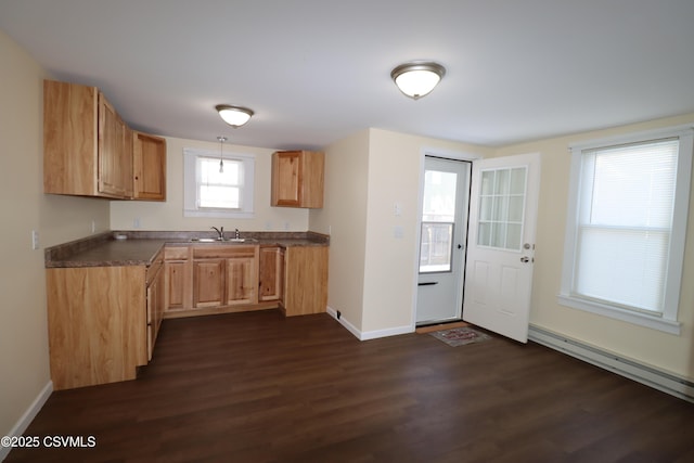 kitchen with light brown cabinetry, a baseboard heating unit, sink, dishwashing machine, and dark hardwood / wood-style floors