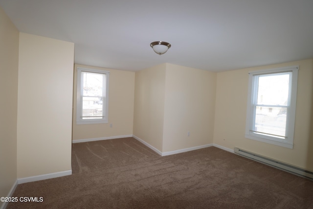 carpeted empty room featuring plenty of natural light and a baseboard heating unit