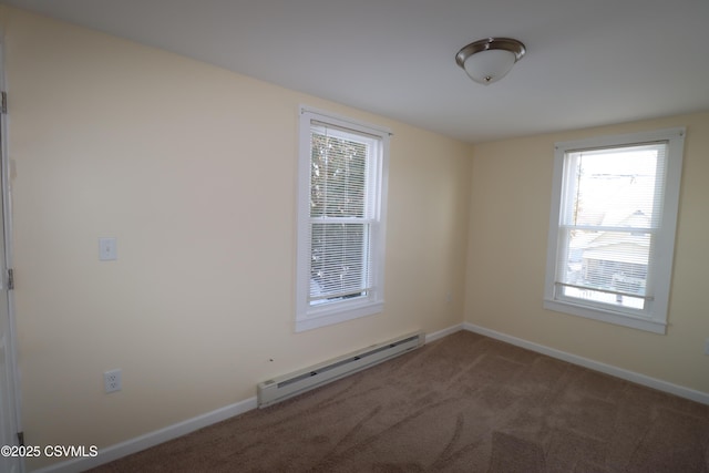 empty room featuring baseboard heating and dark carpet