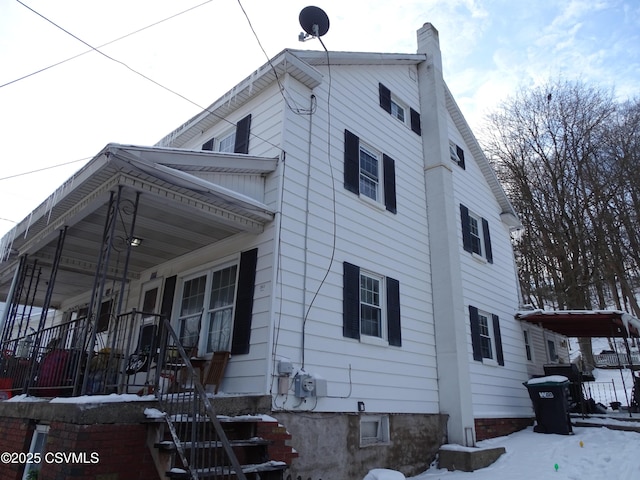 view of snow covered exterior featuring covered porch