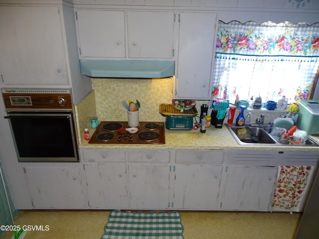 kitchen with cooktop, sink, white cabinetry, tasteful backsplash, and wall oven