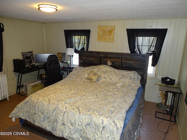 bedroom featuring hardwood / wood-style flooring and radiator